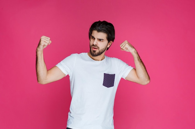 A fan showing his fist and muscles as his team won. 