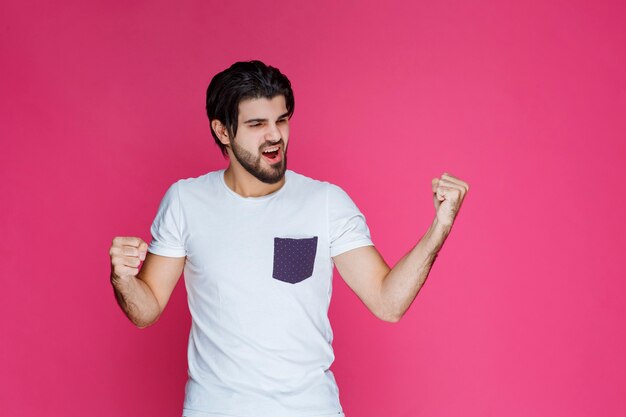 A fan showing his fist and muscles as his team won. 