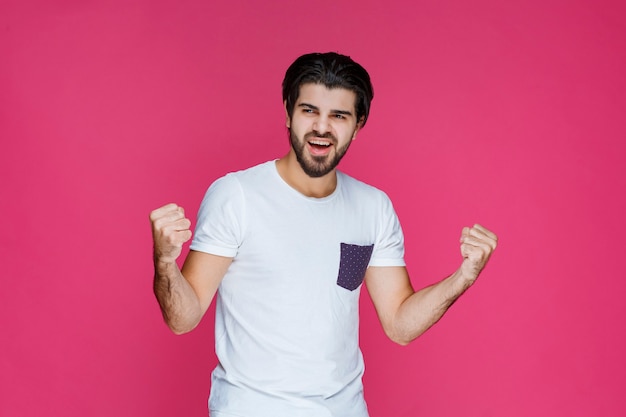 A fan showing his fist and muscles as his team won. 