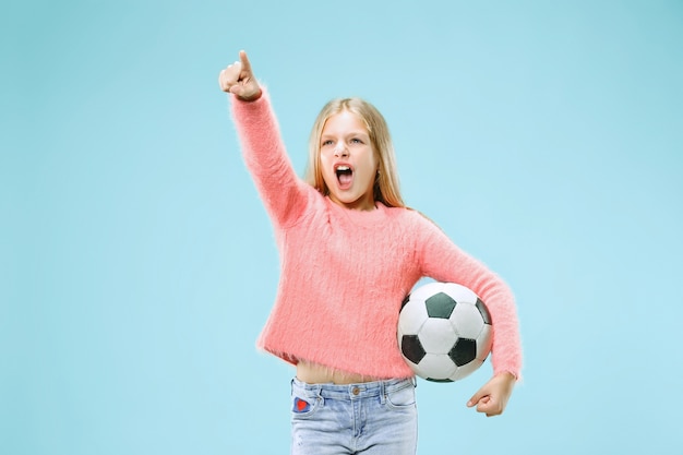 Фан-спорт подросток игрок держит футбольный мяч, изолированные на синем фоне