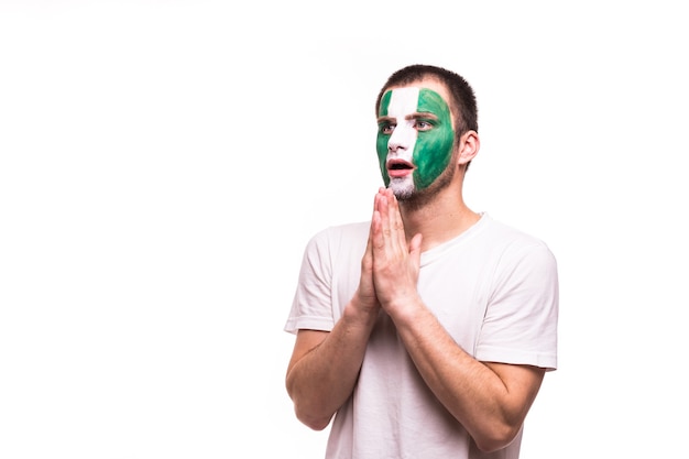 Il supporto dei fan della squadra nazionale della nigeria prega con la faccia dipinta isolata su fondo bianco