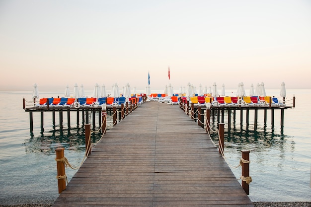 Free photo fantastic colorful deckchairs on wooden walkway