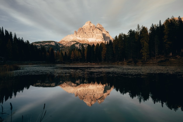 Fantastic landscape view of Dolomites Mountain Range reflecting on a calm alpine lake in Italy