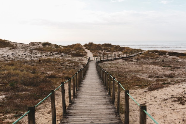 Fantastic shot of a wooden road to the sandy beach