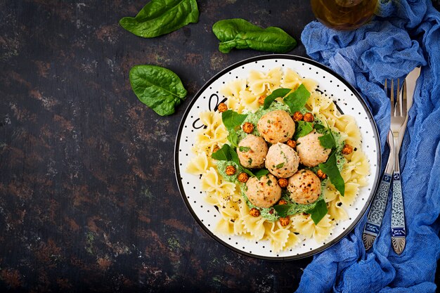 Farfalle pasta with meatballs and spinach sauce with fried chickpeas