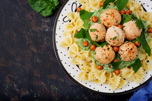 Farfalle pasta with meatballs and spinach sauce with fried chickpeas