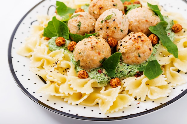 Farfalle pasta with meatballs and spinach sauce with fried chickpeas.