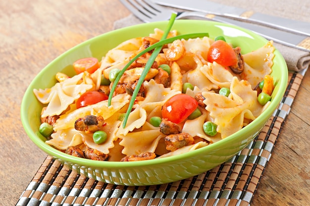 Farfalle pasta with seafood, cherry tomatoes and green peas