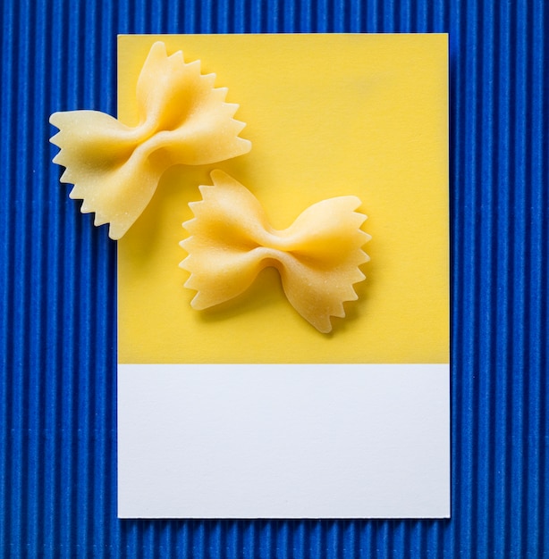 Free photo farfalle pasta on a yellow card