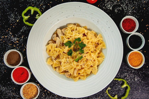 Free photo farfalle with chicken and mushroom garnished with grated parmesan