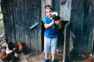 Foto gratuita concetto dell'azienda agricola con il bambino che tiene il tacchino