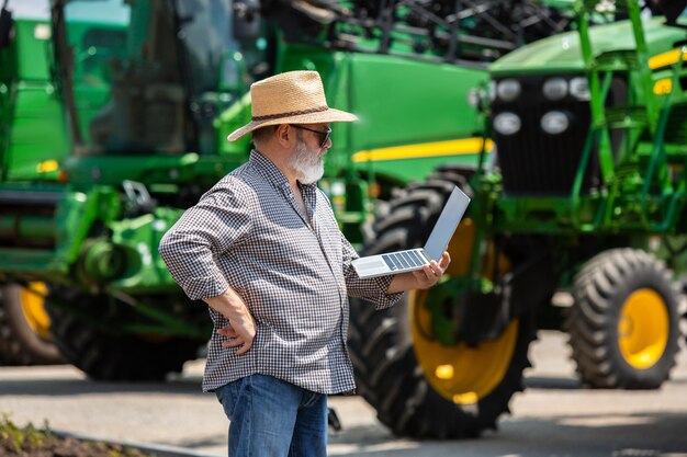 A farmer with tractos and laptop