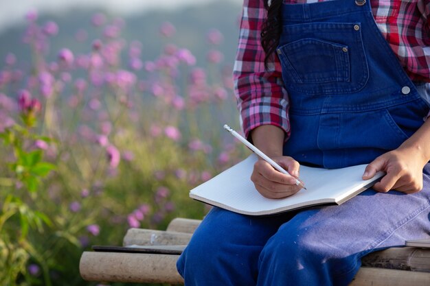 Farmers women are taking notes in the flower garden.