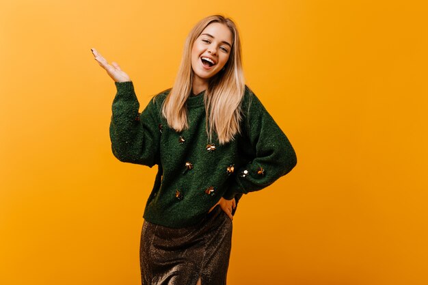 Fascinating white woman in oversize sweater expressing sincere emotiins. Indoor portrait of lovable woman with beautiful smile.