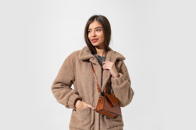 Foto gratuita donna affascinante in posa di cappotto di pelliccia di inverno.