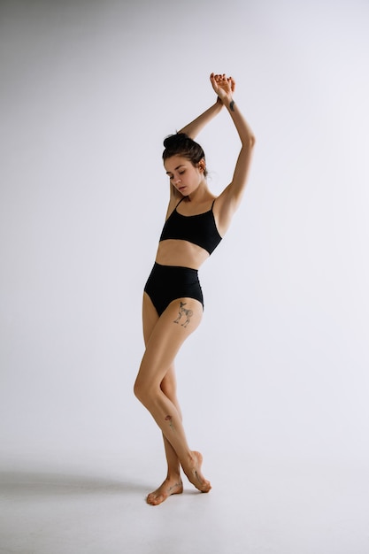 패션 발레. 흰색 배경에 검정 bodysuit에서 젊은 여성 발레 댄서.