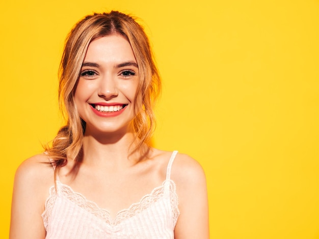 Fashion beauty portrait of young brunette woman with natural stylish makeup and perfect clean skin Sexy model with long curly hair posing in studio on yellow background