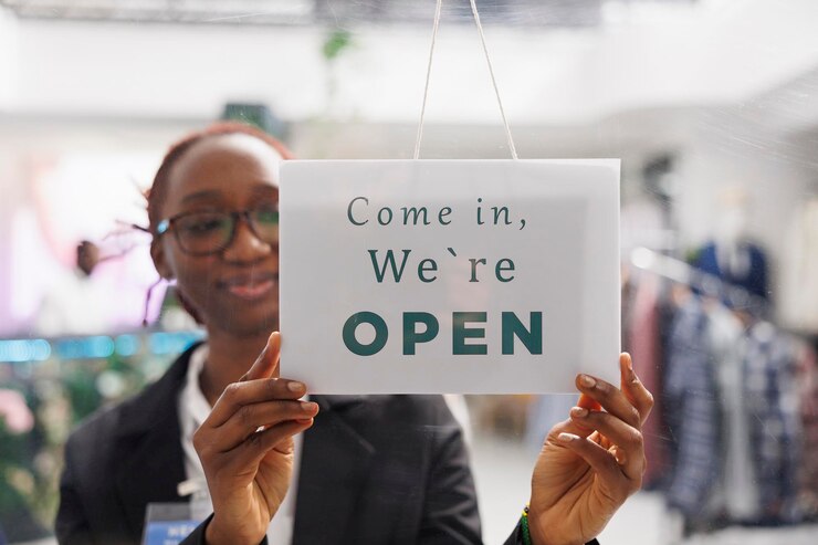 Free Photo fashion boutique shop employee hanging we are open sign