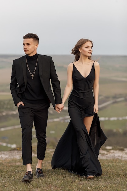 модная пара в черном платье и костюме