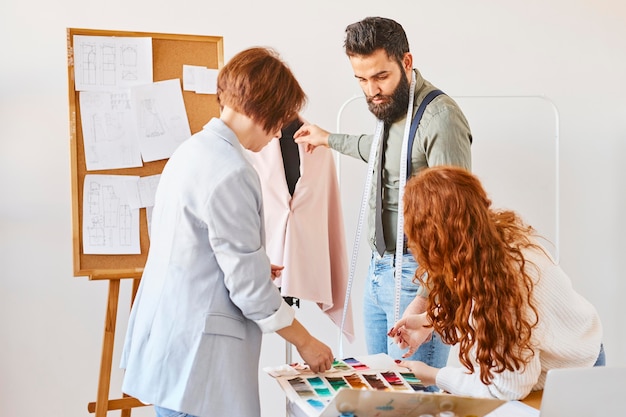 Fashion designers working in atelier with dress form