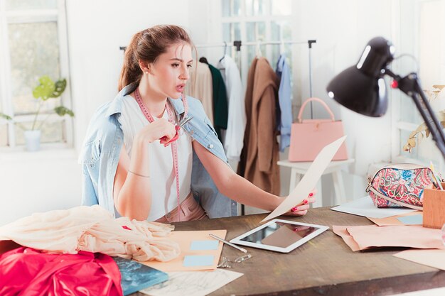 Fashion designers working in studio sitting on the desk