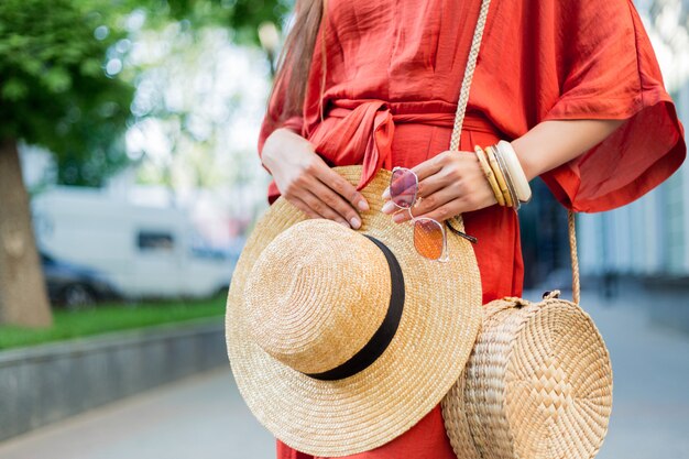 Fashion details.  Woman in amazing stylish coral summer dress posing on the street