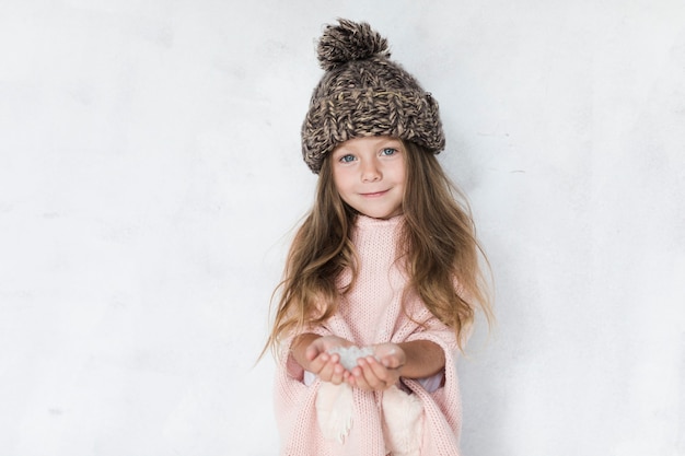 Модно одетая маленькая девочка смотрит на фотографа