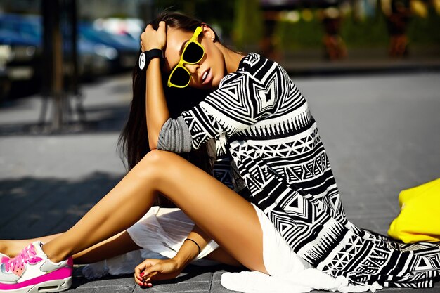 Fashion funny  glamor stylish sexy smiling  beautiful  young woman model in hipster summer clothes sitting in the street with shopping bright yellow bag