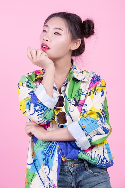 Fashion girl dress up with hand gestures on a pink background.