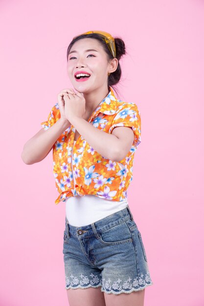 Fashion girl dress up with hand gestures on a pink background.