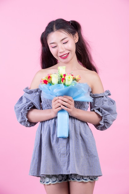 Fashion girl dress up with hand gestures on a pink background.