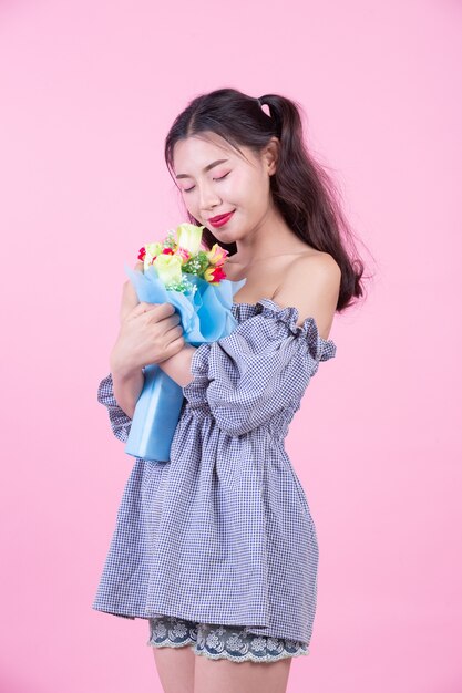 Fashion girl dress up with hand gestures on a pink background.