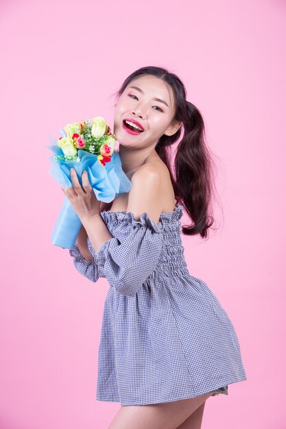 Fashion girl dress up with hand gestures on a pink background.