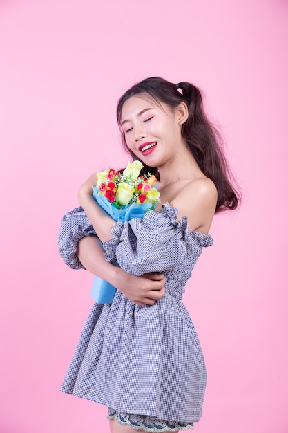 Fashion girl dress up with hand gestures on a pink background.