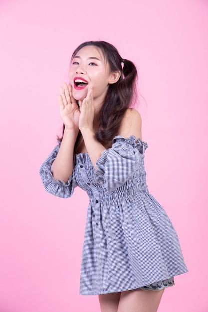 Fashion girl dress up with hand gestures on a pink background.