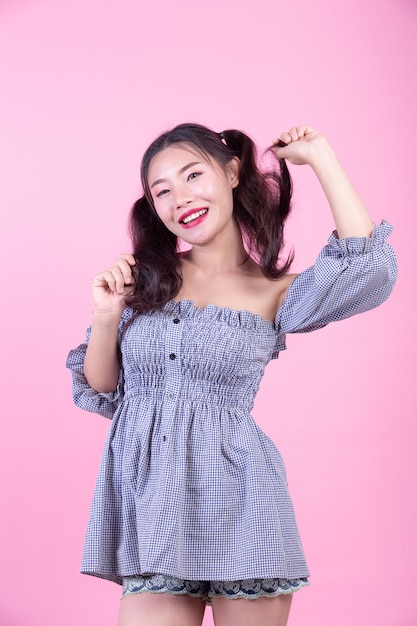 Fashion girl dress up with hand gestures on a pink background.