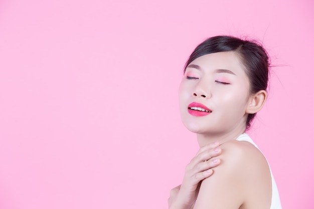 Fashion girl dress up with hand gestures on a pink background.