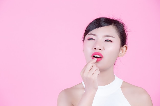 Fashion girl dress up with hand gestures on a pink background.