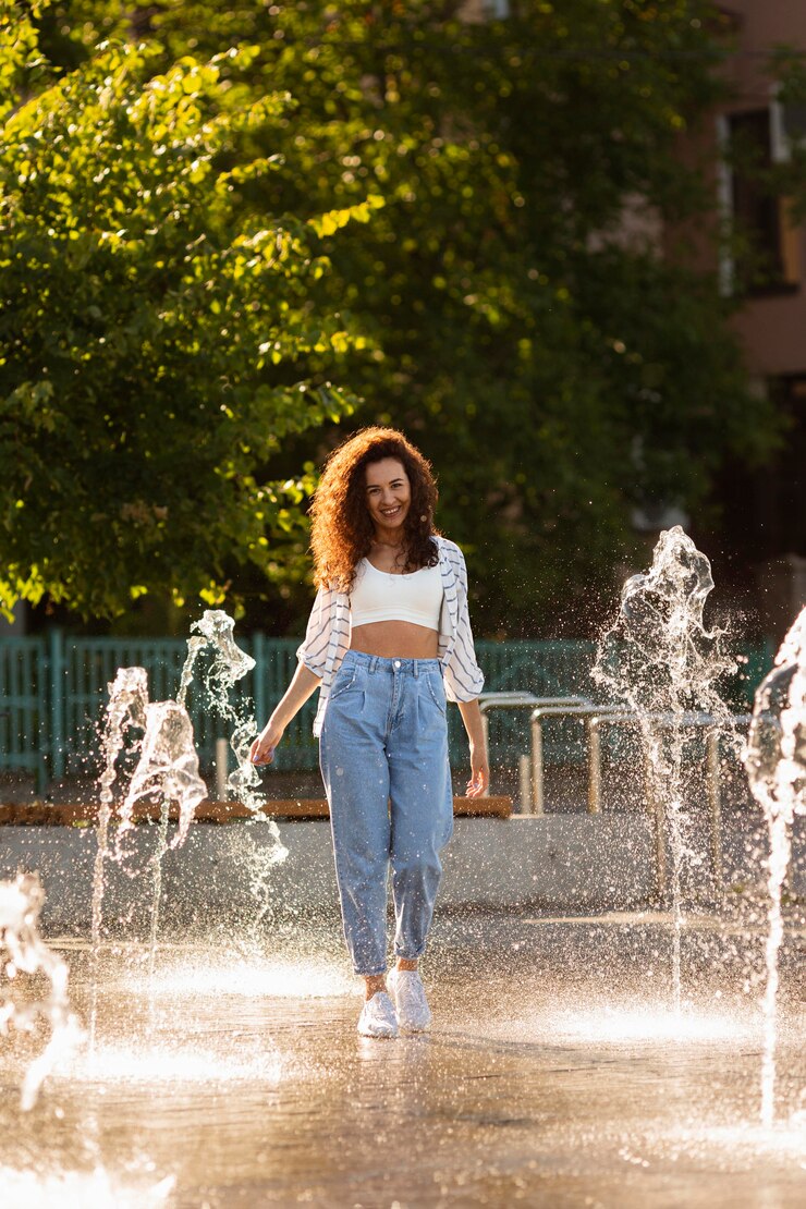 Free Photo fashion girl posing surrounded by a fountain