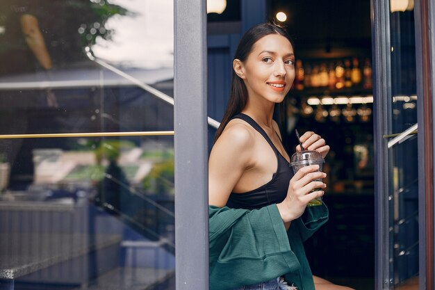 夏のカフェに立っているファッションの女の子