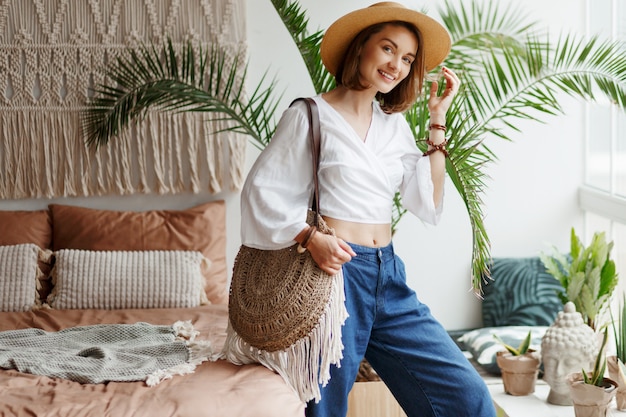 Fashion image of stylish brunette woman posing at home in boho style