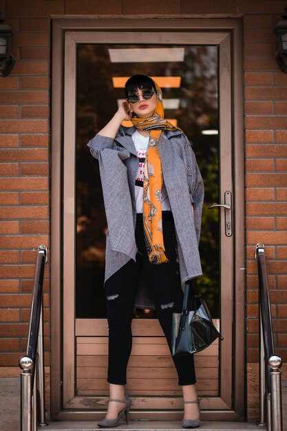 Fashion model in grey jacket and orange shawl