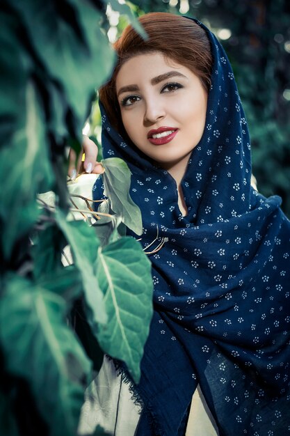 Fashion model in old ethnic style oriental dress with head shawl in the nature