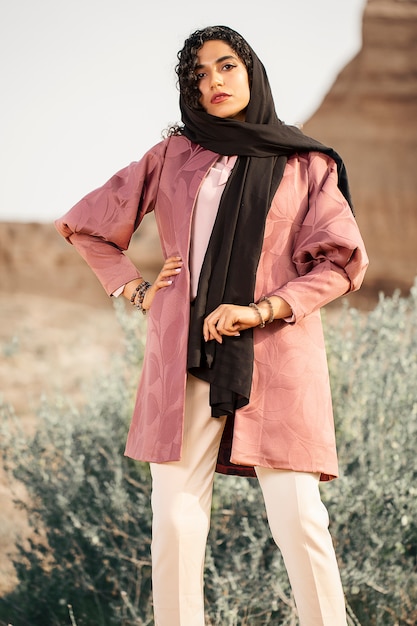 Fashion model in pink jacket in outdoors, with black head cover