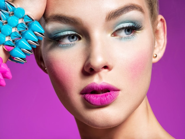 Фотомодель с ярким макияжем и творческой прической Женщина с модным макияжем Портрет крупным планом