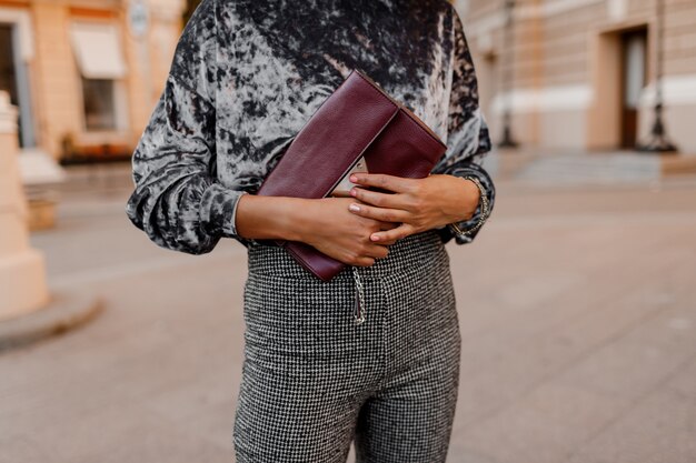 Модные объекты. Чернокожая женщина держит в руках роскошную сумку