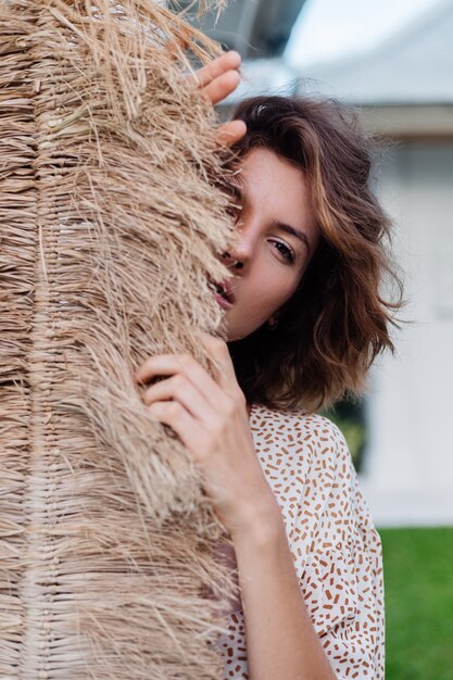 Fashion outdoor portrait of brunette short hair woman with broom