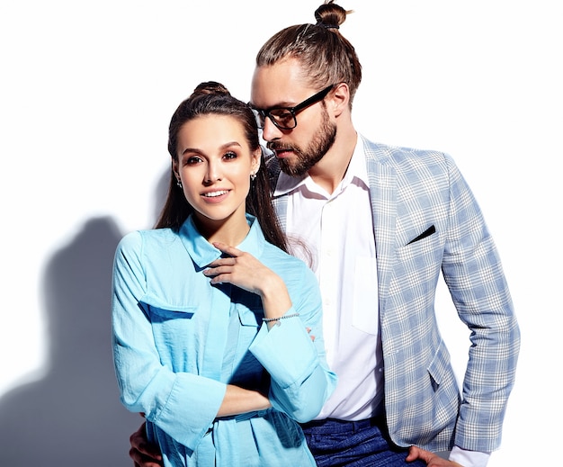 Fashion photo of handsome elegant man in glasses in suit with beautiful sexy woman in colorful dress on white