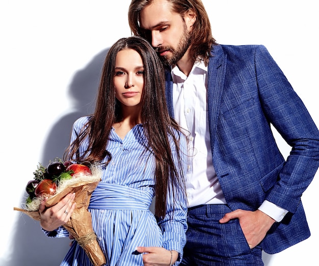 Fashion photo of handsome elegant man in suit with beautiful sexy woman in colorful dress on white.