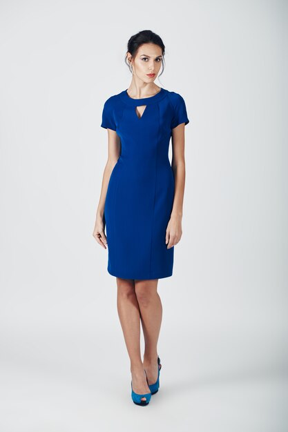 青いドレスの若い壮大な女性のファッション写真